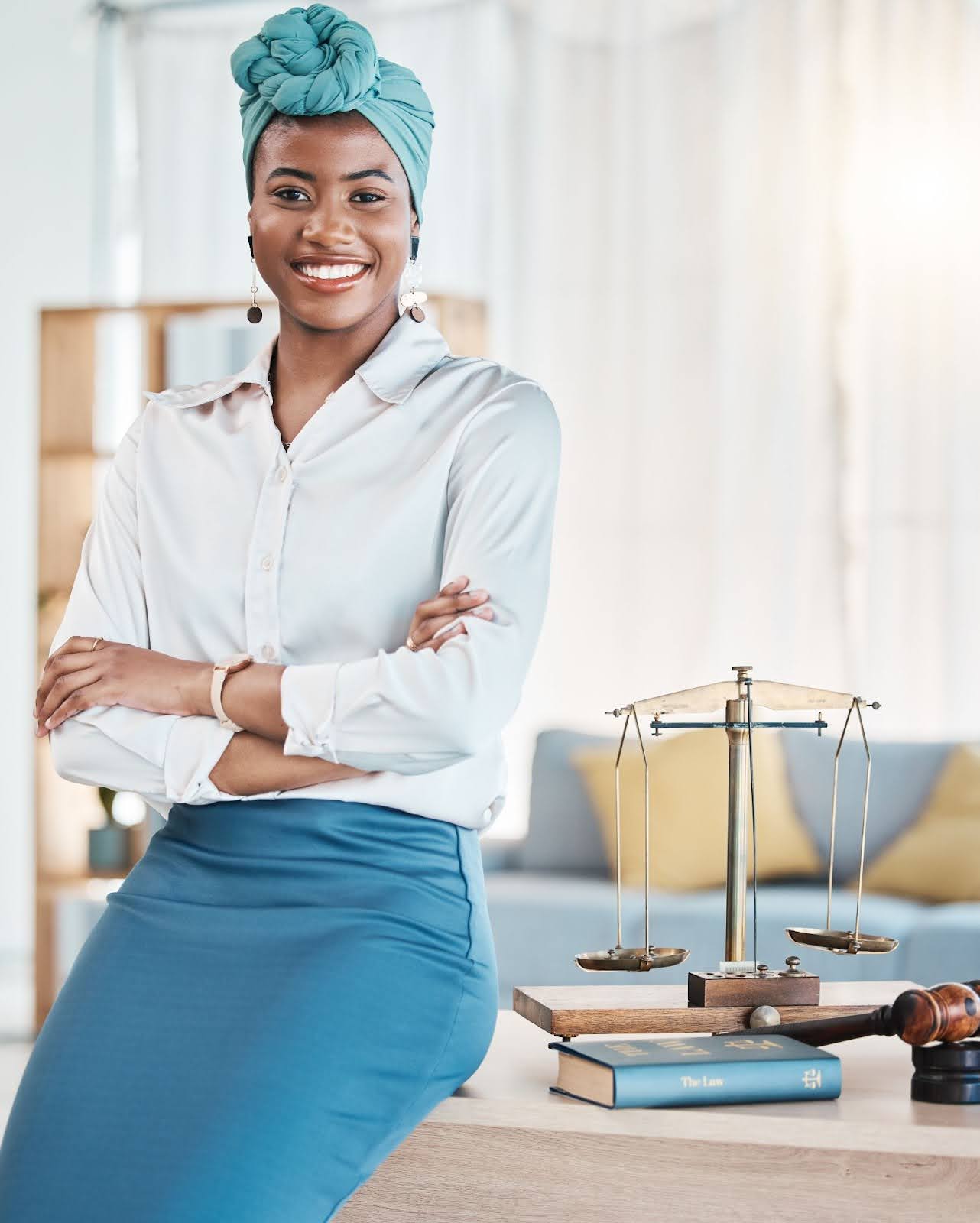 A lawyer who is smiling and sitting on her desk because she has done her homework and learned all the new California employment laws in 2026 for employers and employees to be aware of.